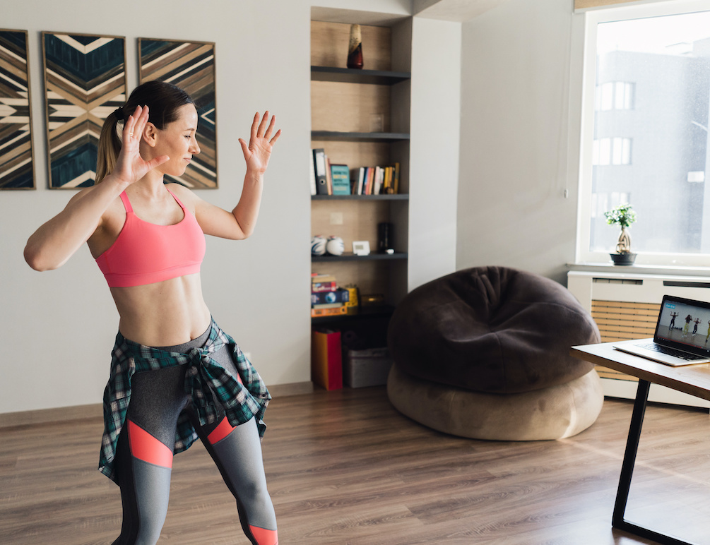 Woman learning a dance routine from laptop